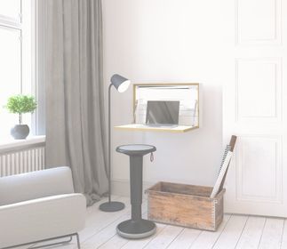 Kleines Homeoffice Ein moderner Raum mit einem Arbeitsplatz, einem Laptop, einem Stehlampe, einem Hocker und einer Holzbox.