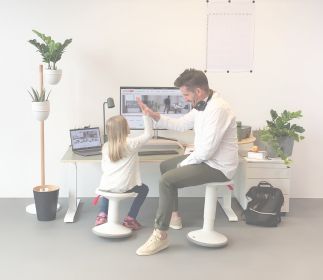 Homeoffice für die ganze Familie Ein Erwachsener und ein Kind in einem modernen Büro, die sich die Hände geben.