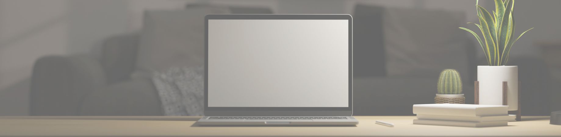Minimalistische Arbeitsplatz-Szene mit Laptop, Büchern und Pflanzen im Hintergrund.
