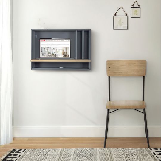 Wandklapptisch in Dunkelblau mit schmaler Arbeitsfläche und hellem Holzstuhl vor weißer Wand