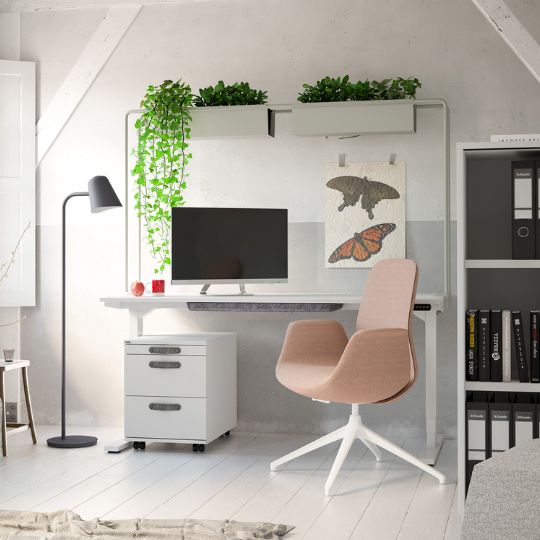 Heller Arbeitsplatz mit höhenverstellbarem Schreibtisch, Monitor und rosa Bürostuhl.