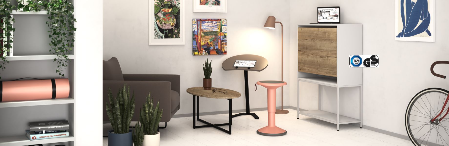 Ein modernes Wohnzimmer mit einem gemütlichen Sessel, einem runden Tisch, Stehlampe und einem höhenverstellbaren Tisch. An der Wand hängen mehrere Kunstdrucke. Im Hintergrund steht ein Regal mit Pflanzen und einem Yogamatte.