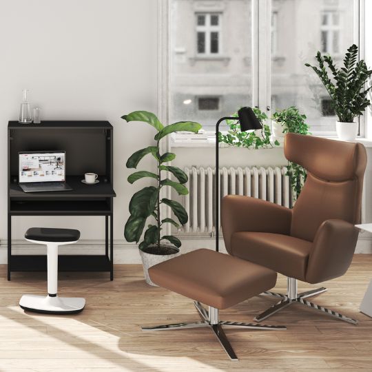 Modernes Homeoffice mit braunem Lounge-Sessel, Pflanzen und kompaktem schwarzen Schreibtisch
