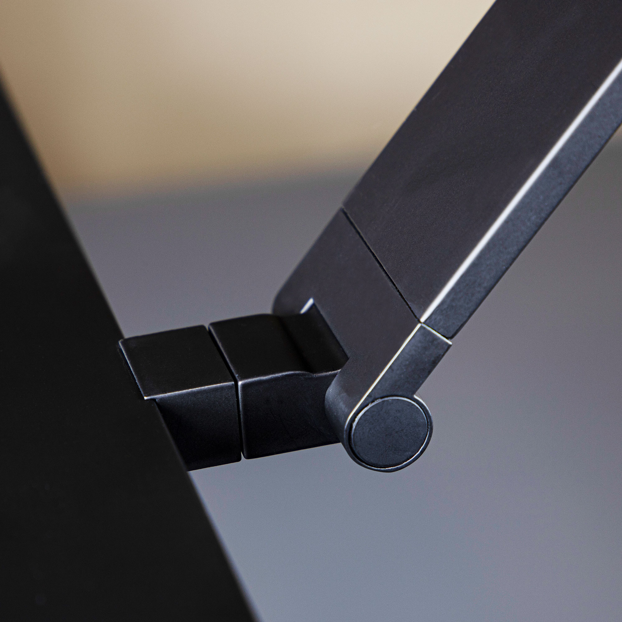 Detailaufnahme eines schwarzen Monitorarms mit Gelenkmechanik
