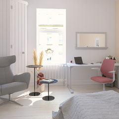 Farbwelt ACTIVE Ein modernes Zimmer mit einem Schreibtisch, einem Stuhl, einem grauen Sessel, zwei kleinen Tischen und einem Fenster.
