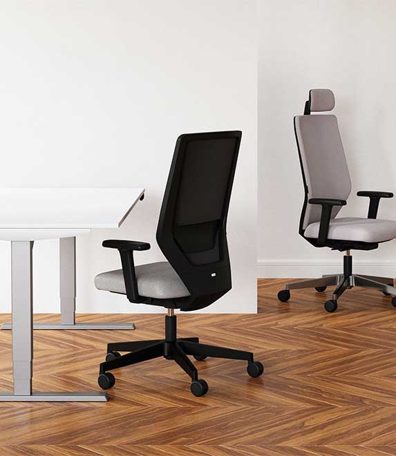 Zwei ergonomische Bürostühle mit Netzrückenlehne und Rollen auf Parkettboden.