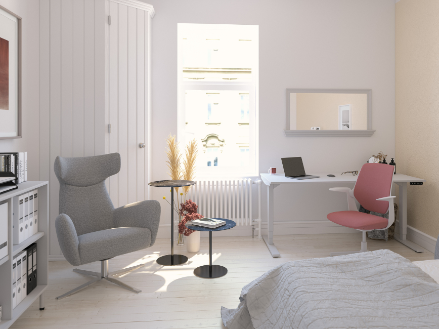 Moderner Homeoffice-Bereich mit grauem Sessel, weißem Schreibtisch und rosa Bürostuhl.