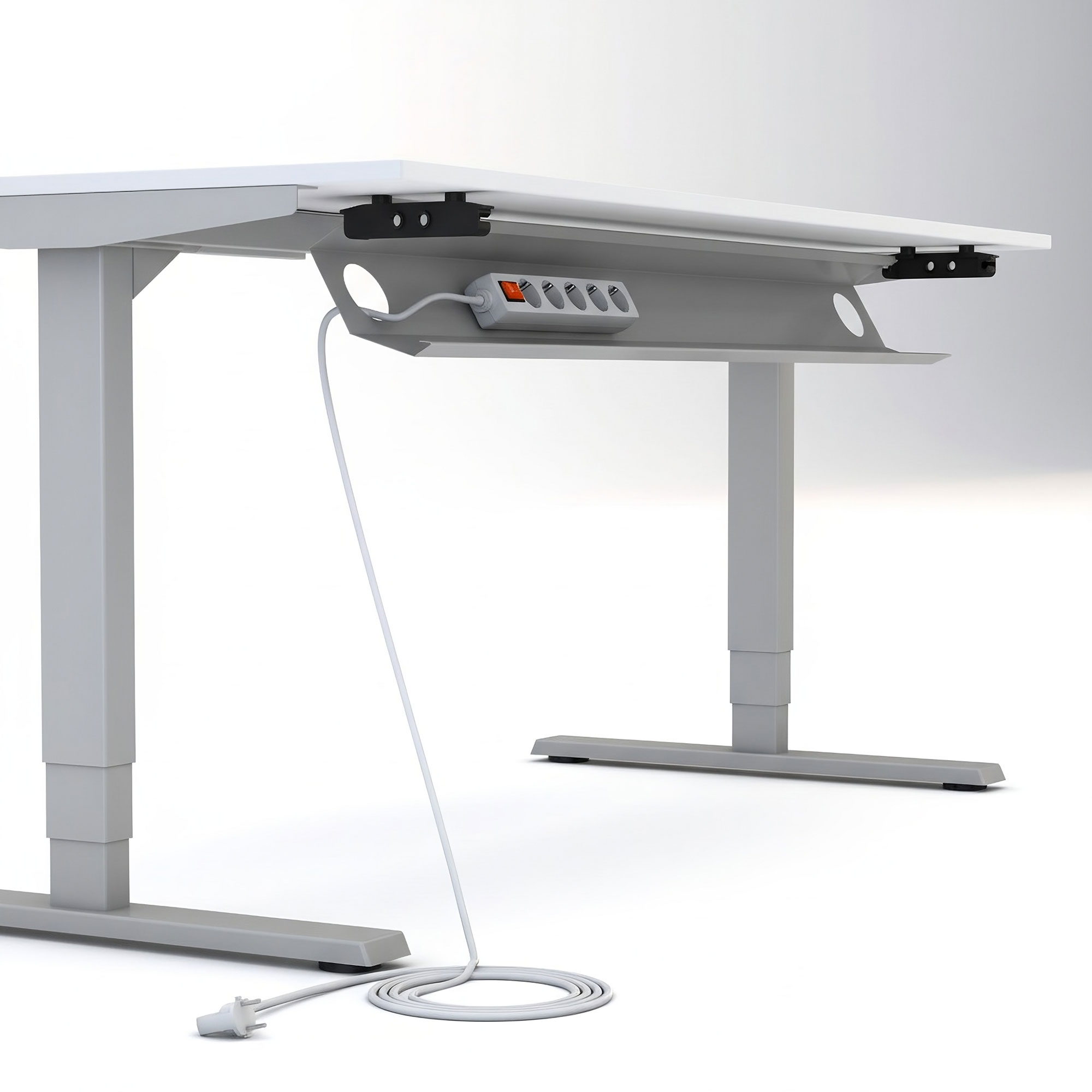 Ein weißer, höhenverstellbarer Schreibtisch mit einem eingebauten Kabelkanal, in dem eine Steckdosenleiste untergebracht ist. Ein weißes Netzkabel reicht von der Ablage bis zum Boden.
