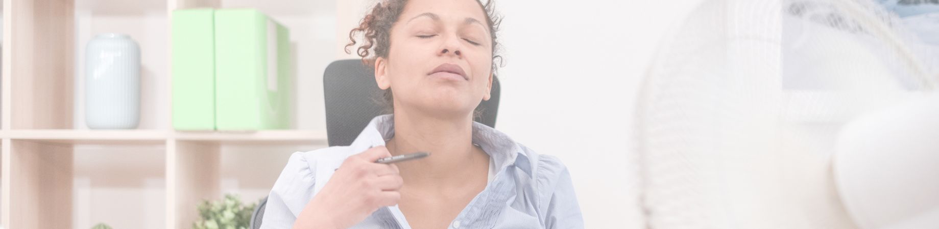 Eine Person sitzt entspannt in einem Bürostuhl, schließt die Augen und hält einen Stift in der Hand. Im Hintergrund sind Regale mit Dekorationsobjekten sichtbar.