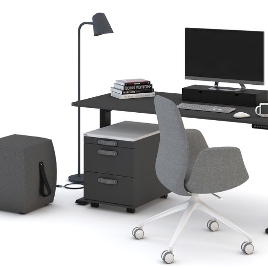 Modernes Homeoffice mit schwarzem Schreibtisch, grauem Drehstuhl, Rollcontainer und Stehlampe.