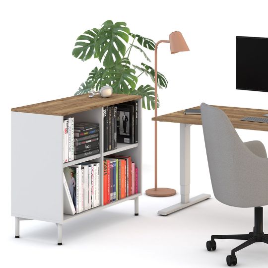 Ein moderner Arbeitsplatz mit einem Bücherregal, einer Stehlampe, einem Schreibtisch und einem Computer.