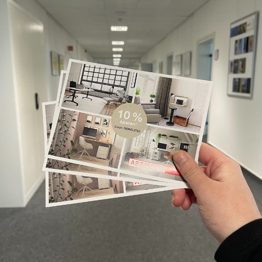 Drei Postkarten mit modernen Büromöbel-Layouts, die einen Rabatt von 10 % anbieten, werden in einem flurenähnlichen Raum gehalten.